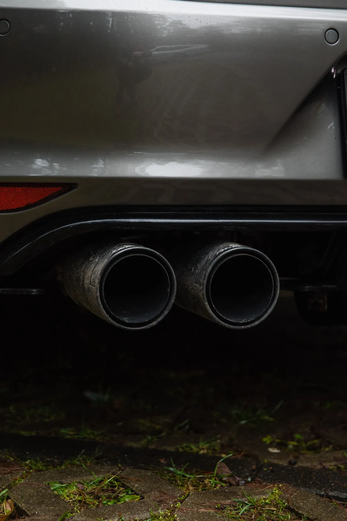 Twin exhaust tailpipes at the rear of a car