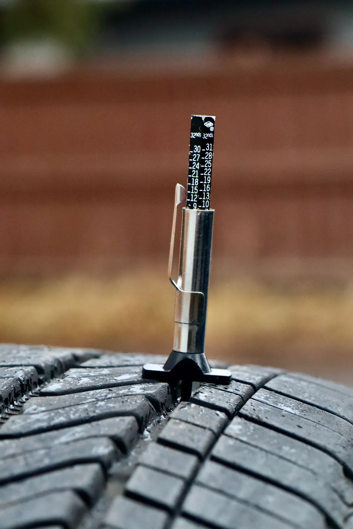A tread depth gauge measuring a tire’s tread